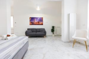 un soggiorno bianco con divano e letto di Elegante Suite con giardino nel centro Lecce - Free Parking - WiFi a Lecce