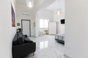 un soggiorno con divano e letto di Elegante Suite con giardino nel centro Lecce - Free Parking - WiFi a Lecce