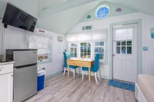 a kitchen with a table and blue chairs in a room at Seaside Cottages - Cottage 23 - SeaGills Rest in South Yarmouth