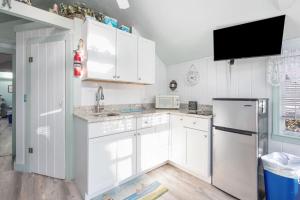 a kitchen with white cabinets and a refrigerator at Seaside Cottages - Cottage 23 - SeaGills Rest in South Yarmouth +27 photos