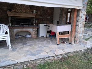 a stone patio with a table and a fireplace at Οικια κοντα μονοπατι των κενταυρων in Portariá