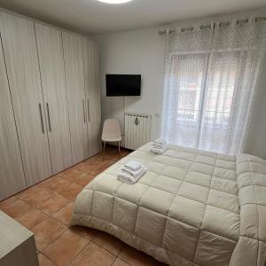 a bedroom with a large white bed and a television at Appartamento Antonietta- in Santa Maria degli Angeli