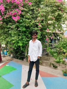 Un hombre parado frente a un jardín con flores rosas. en Jurain Dhaka, en Dhaka 7 fotos más