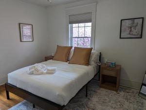 a bed with two towels on it in a bedroom at New! Renovated 2br1ba Near Ncssm in Durham