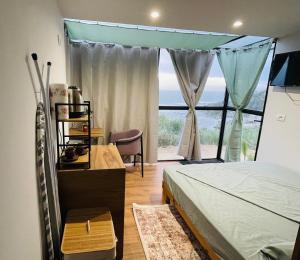 都拉斯Beus home 2的一间卧室,里面有一张床和一扇大窗户。