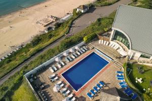 an overhead view of a swimming pool next to a beach at Bournemouth Highcliff Marriott Hotel in Bournemouth