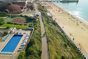 an aerial view of a beach with a pool and a tennis court at Bournemouth Highcliff Marriott Hotel in Bournemouth