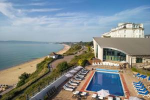 a hotel with a swimming pool next to a beach at Bournemouth Highcliff Marriott Hotel in Bournemouth