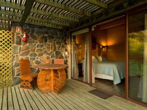 a wooden porch with a table and a bedroom at Olmue Natura Lodge & Spa in Olmué +60 photos