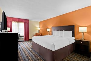 a hotel room with a large bed and a flat screen tv at Best Western Kenosha Inn in Broken Arrow