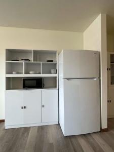 a white kitchen with a refrigerator and white cabinets at Unit 3 - Stand Rock Studios in Wisconsin Dells