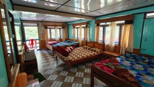 a room with three beds and windows on a train at Sisney River Retreat in Rongli