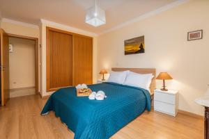 una camera da letto con un letto blu con due asciugamani sopra di Bright & Spacious Flat by HostWise a Vila Real de Santo António
