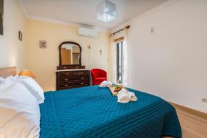 una camera con un letto blu e una sedia rossa di Bright & Spacious Flat by HostWise a Vila Real de Santo António