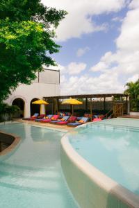 a large swimming pool with lounge chairs and umbrellas at Café Jeri Hotel in Jericoacoara