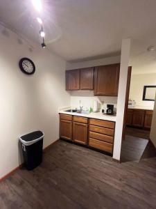 トーマにあるTomah Apartment - 201 E Veterans Unit Jの木製キャビネット付きのキッチン、壁掛け時計 +12枚の写真