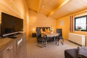 ein Zimmer mit einem Tisch mit Stühlen und einem Fernseher in der Unterkunft Pension Bernhardt in Schwarzenberg/Erzgebirge