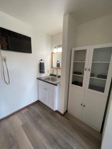 a white kitchen with a sink and a mirror at Unit 8 - Stand Rock Studios in Wisconsin Dells