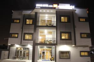 ヌアクショットにあるUrban Hotel Suitesの夜に窓のある背の高い白い建物