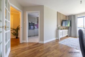a living room with white walls and a hard wood floor at Belfast Quarters Riverside in Belfast
