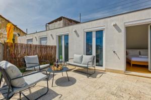 eine Terrasse mit Stühlen, einem Tisch und einem Bett in der Unterkunft InLoveApartments - Luxury in Alfama in Lissabon