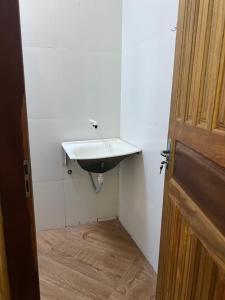 a bathroom with a sink next to a door at Chalé aconchegante no Prado - Ar, Wi-Fi e ótima localização in Prado