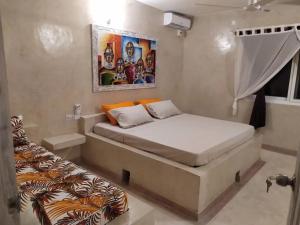 un pequeño dormitorio con una cama y una pintura en la pared en Family Villa with Private Pool in Watamu, 130 m², en Watamu