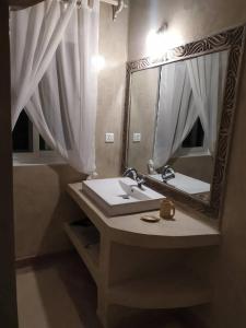 un baño con lavabo y espejo en Family Villa with Private Pool in Watamu, 130 m², en Watamu