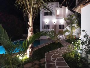 una villa con piscina por la noche en Family Villa with Private Pool in Watamu, 130 m², en Watamu 13 fotos más