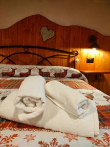 Una cama con dos toallas blancas. en casa vacanza la Slitta, en Roure Turin