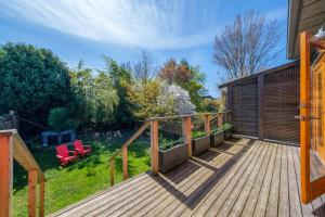eine Holzterrasse mit zwei roten Stühlen darauf in der Unterkunft Cozy Heritage Home Near Main St in Vancouver