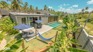 ein Haus mit einer Hängematte und einem Pool in der Unterkunft Casa com Piscina na Praia de Tatuamunha by Qavi in Tatuamunha