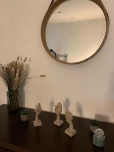 a table with a mirror and some wooden figurines on it at Studio cosy avec jardin in Jonquières +7 photos