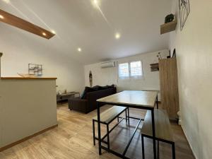 a living room with a table and a couch at Chez Zelie in Canet-en-Roussillon