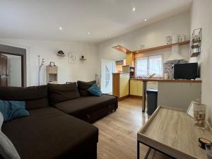 a living room with a couch and a table at Chez Zelie in Canet-en-Roussillon