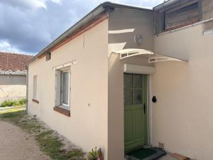 a white house with a green door at La Maison Bellagio - Classée 3 étoiles in Ingré