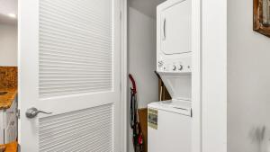 une porte menant à une cuisine équipée d'un réfrigérateur. dans l'établissement Juno Beach Seaside Escape Steps from the Ocean!, à Juno Beach 21 autres photos