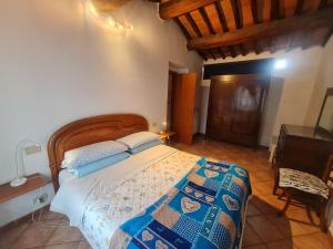 Un dormitorio con una cama con cabecero de madera. en Exploring tuscany, en Chiesina Uzzanese 5 fotos más