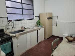 a kitchen with a refrigerator and a sink and a table at Casona Villa General Savio in Villa General Savio +3 photos