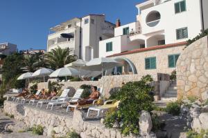 a group of people sitting in lounge chairs at a resort at Villa Simpatia in Primo&scaron;ten