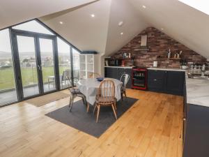 Una cocina y un comedor con mesa y sillas. en The Willows, en Newport