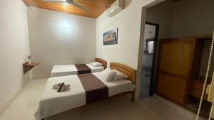 a hotel room with two beds and a sliding door at Hotel kerana moon in Puerto Boyacá