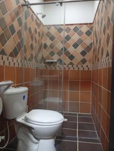 a bathroom with a toilet and a shower at Hotel kerana moon in Puerto Boyacá