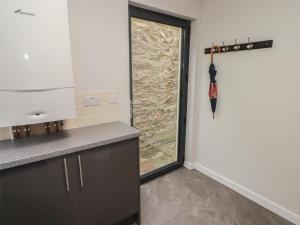 Una cocina con una ventana y una sombrilla en la pared. en The Willows, en Newport 32 fotos más