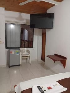 a living room with a flat screen tv on the wall at Hotel kerana moon in Puerto Boyacá
