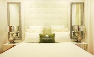 a white bed with pillows and pillows on top of it at Milfontes Guest House - Duna Parque Group in Vila Nova de Milfontes