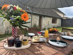 a wooden table with a vase of flowers on it at Maison Belles Pierres in Montagny-lès-Beaune