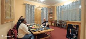 a group of people sitting at a table in a room at Moonshine Homestay Kashmir in Srinagar