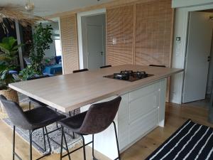 a kitchen with a large island with chairs around it at Maison bohème chic, Saint-Pair sur mer, 7 pers, 15 mn à pieds de la plage, navette gratuite in Saint-Pair-sur-Mer +18 photos