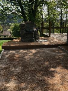 a wooden deck with a stone bench in a yard at Chalet le Faye in Waimes +9 photos